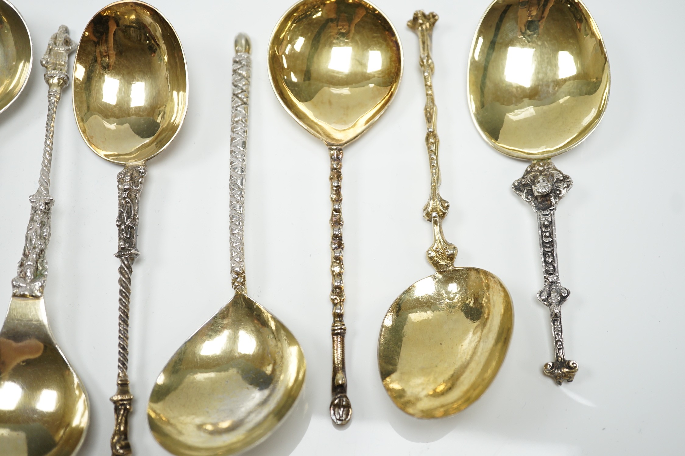 Twelve assorted 19th century and later Scandinavian or Dutch? gilt or parcel gilt white metal spoons, with differing stems including apostle, largest 18.8cm, 19.3oz.